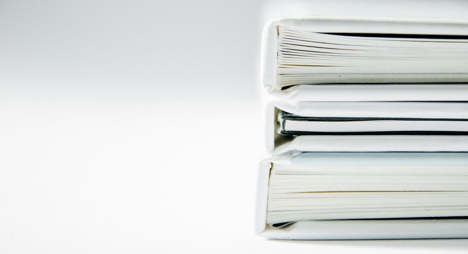 白い表紙で製本された報告書の束
